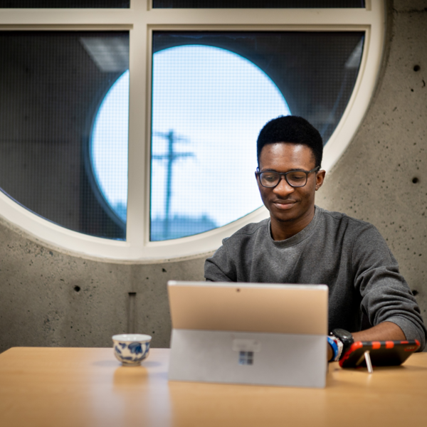 A student working on his computer in a meeting room